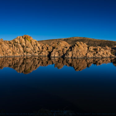 Dark blue Arizona lake lined by rocky hills.